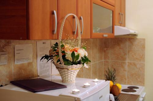 a basket of flowers sitting on top of a kitchen counter at IWA CENTAR Apartments & Wellness in Vrnjačka Banja