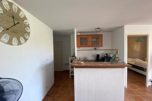 une cuisine avec une grande horloge murale dans l'établissement The central gardens, à Frontignan