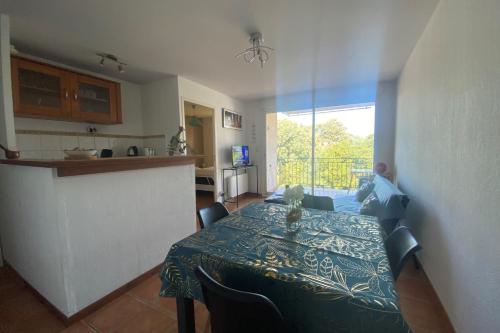 une salle à manger avec une table et une cuisine dans l'établissement The central gardens, à Frontignan