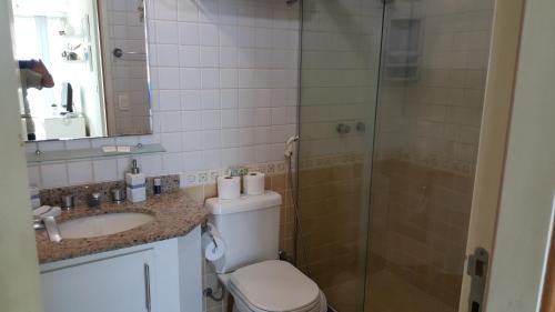 uma casa de banho com um chuveiro, um WC e um lavatório. em Cobertura em Frente ao Mar no Recreio no Rio de Janeiro