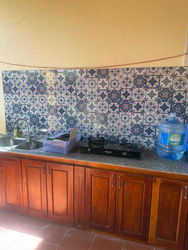 a kitchen counter with a sink and a tile wall at Duke Bungalow in Phu Quoc