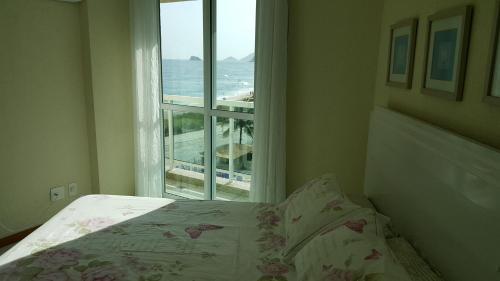 Tempat tidur dalam kamar di Cobertura em Frente ao Mar no Recreio