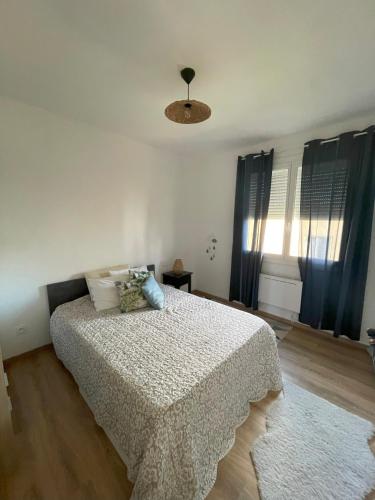 une chambre avec un lit avec une couette blanche dans l'établissement Charmante maison individuelle à Limoux, à Limoux