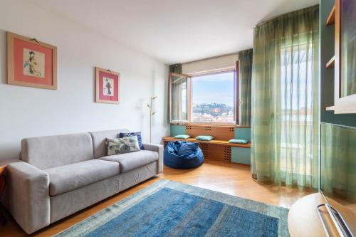 a living room with a couch and a large window at Centralissimo con vista colline in Conegliano