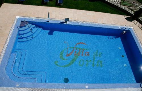 a blue swimming pool with the words into the water at Hotel Villa de Torla in Torla