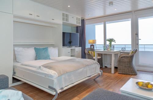 a bedroom with a large bed and a desk with a computer at Metropol Oceanlounge 309A in Westerland (Sylt)