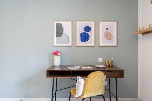 a desk in a room with three pictures on the wall at Zenao Appart'hôtels Villeneuve d'Ascq in Villeneuve d'Ascq