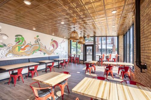 a restaurant with wooden tables and red chairs at Crosby Lofts in Crosby