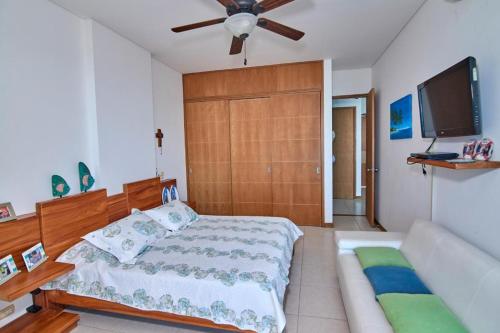 a bedroom with a bed and a flat screen tv at Hermoso Apartamento Frente al Mar 2 Habitaciones PAZ146 in Coveñitas