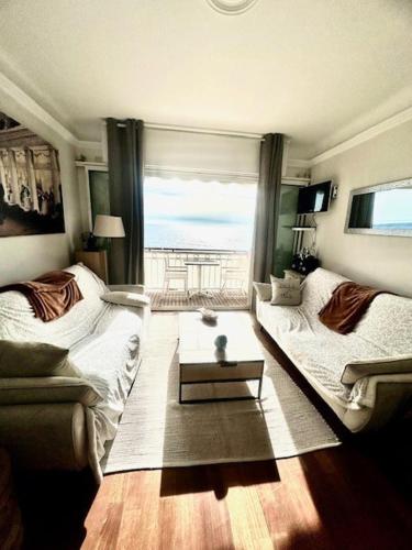 un salon avec un canapé et une table dans l'établissement Appartement face mer proche palais, à Cannes