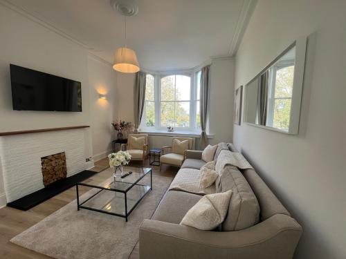 a living room with a couch and a fireplace at Hurstpier Spacious 2 Bed Apartment - by MCF in Hurstpierpoint