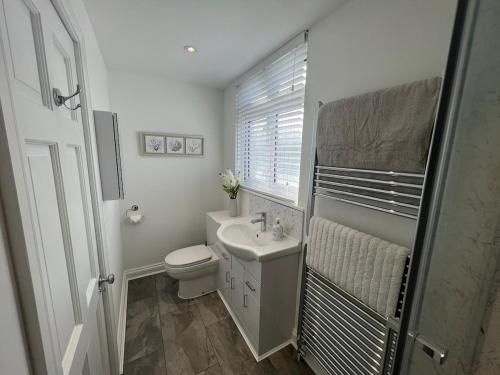 Un baño blanco con inodoro y lavabo. en Hurstpier Spacious 2 Bed Apartment - by MCF, en Hurstpierpoint