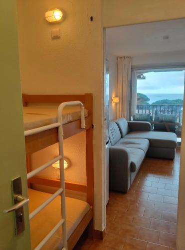 - un salon avec un canapé et des lits superposés dans l'établissement CHARMANT STUDIO AVEC TERRASSE et VUE MER EXCEPTIONNELLE, à Sainte-Maxime
