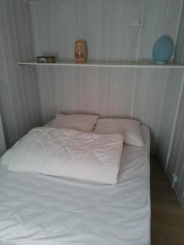 un lit avec des draps blancs et des oreillers dans une chambre dans l'établissement Monplaisir, à Gère-Belesten