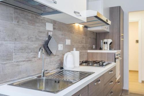 una cocina con fregadero y estufa en St Peter apartment with Garage, en Roma