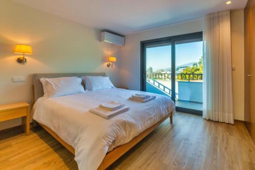 a bedroom with a bed and a large window at Quinta de Casal do Bairro Casa Grande in Guimarães