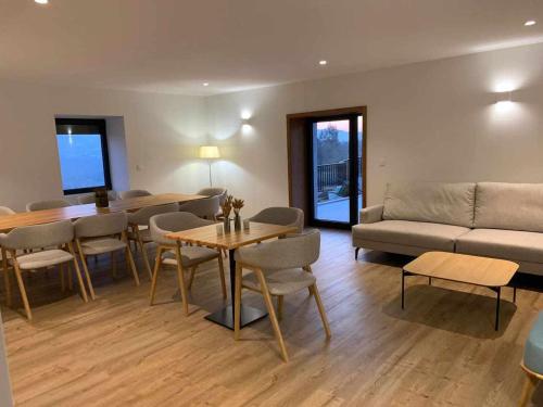 a living room with a couch and a table and chairs at Quinta de Casal do Bairro - Casa Grande in Guimarães