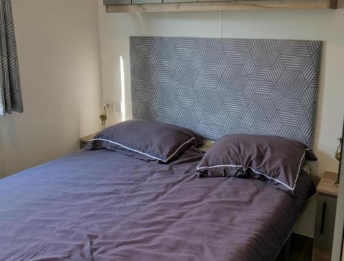 a bed with two pillows in a bedroom at Camping Zavelbos Superior Chalet in Maaseik