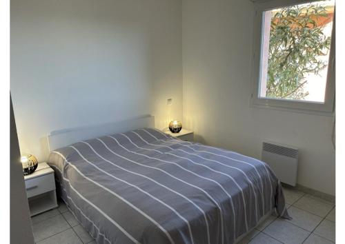une chambre blanche avec un lit et une fenêtre dans l'établissement SP020-B002 Appartement 2 pièces Saint Pierre la Mer, à Saint Pierre La Mer