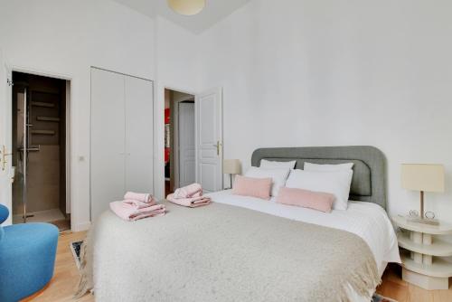 a bedroom with a large bed with pink towels on it at Luxury Paris, paisible, 2 chambres, toute commodités in Paris