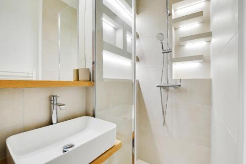 une salle de bain blanche avec un lavabo et une douche dans l'établissement Luxury Paris, paisible, 2 chambres, toute commodités, à Paris