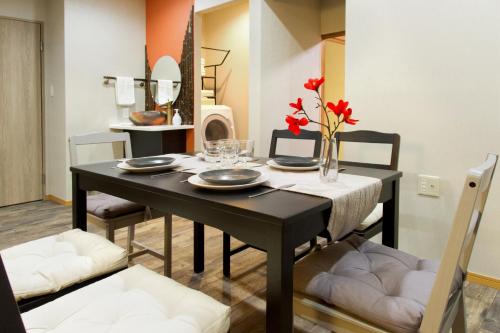a dining room with a black table and chairs at 楓の宿1号館 in Osaka