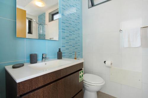 Un baño con lavabo, inodoro y espejo. en Original Wave House, en Jardim do Mar