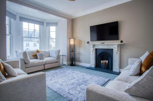 a living room with two couches and a fireplace at The Lanterns - 9 Bedroom - Sleeps 17 - Saundersfoot Village Centre in Saundersfoot