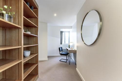 un couloir avec des étagères en bois et un miroir dans l'établissement Amazing Apartment 4Bedrooms Champs Elysées, à Paris