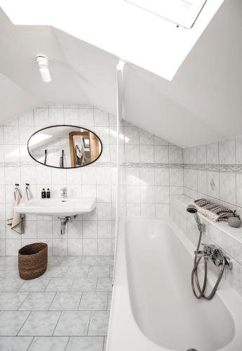 a white bathroom with a tub and a sink at Appartement no8 in Sankt Gilgen