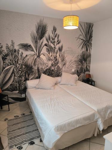 - une chambre dotée d'un lit avec des plantes sur le mur dans l'établissement Maison indépendante en plein cœur de Dolus, à Dolus-d'Oléron