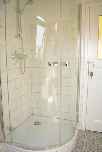 a shower with a glass door in a bathroom at DE103 - Charming farm style home on a large estate in Domburg