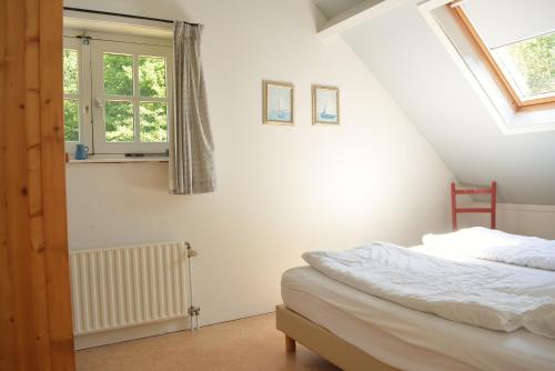 a bedroom with a bed and a window at DE103 - Charming farm style home on a large estate in Domburg