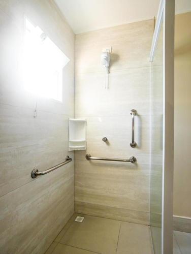 a bathroom with a shower with a glass door at Hotel Rosenbrock in Balneário Camboriú