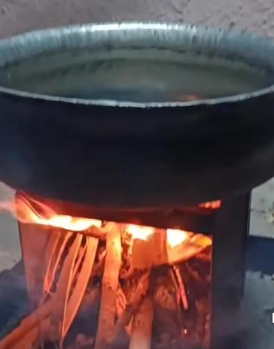 a pot on top of a stove with fire at Siva Rama garden resort & swimming pool 5star stay comfort 6BHK bheemili beach road nr in Visakhapatnam