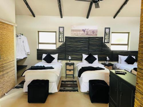 a bedroom with three beds in a room at Shiringa kruger lodge in Marloth Park