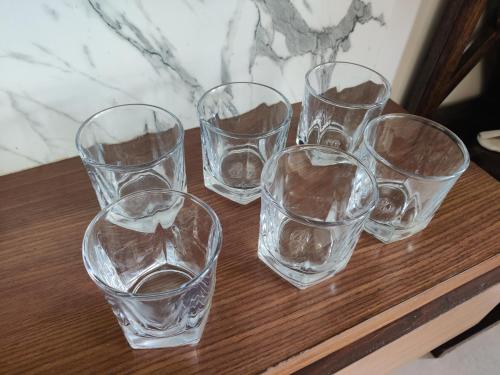 a group of glasses sitting on a wooden table at Siva Rama garden resort & swimming pool 5star stay comfort 6BHK bheemili beach road nr in Visakhapatnam