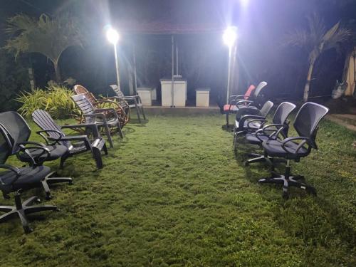a row of chairs sitting in the grass at night at Siva Rama garden resort & swimming pool 5star stay comfort 6BHK bheemili beach road nr in Visakhapatnam