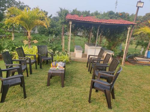 a group of chairs sitting in the grass with a grill at Siva Rama garden resort & swimming pool 5star stay comfort 6BHK bheemili beach road nr in Visakhapatnam