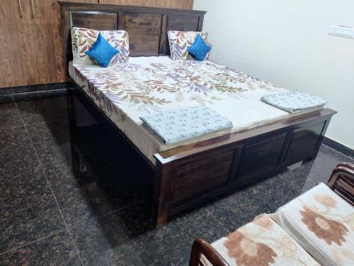 a bed with a wooden frame in a room at Siva Rama garden resort & swimming pool 5star stay comfort 6BHK bheemili beach road nr in Visakhapatnam
