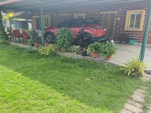 a motorcycle parked in front of a house with plants at Siva Rama garden resort & swimming pool 5star stay comfort 6BHK bheemili beach road nr in Visakhapatnam