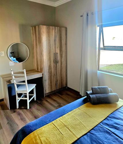 a bedroom with a bed and a mirror and a chair at Casa Cara Resort in Parys