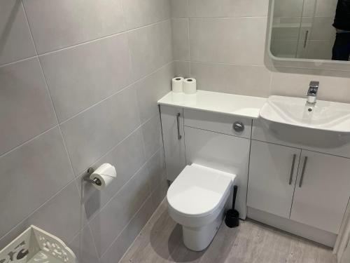 a white bathroom with a toilet and a sink at The Wildings Hotel & Tudno's Restaurant in Llandudno
