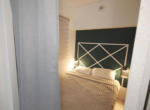 une chambre avec un lit avec une tête de lit noire dans l'établissement Lovely 2 rooms 25m2 - pool - AC - terrace, à Antibes