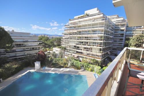 un grand immeuble d'appartements avec une piscine sur un balcon dans l'établissement Lovely 2 rooms 25m2 - pool - AC - terrace, à Antibes