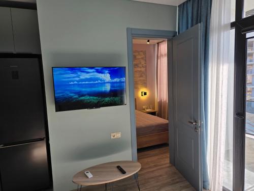 a room with a television on a wall with a bed at Davit apartments in Makhinjauri