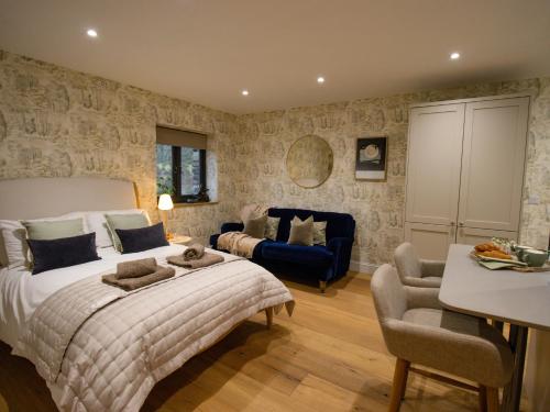 a bedroom with a large bed and a blue couch at Hardriggs Bank Cottage in Kendal