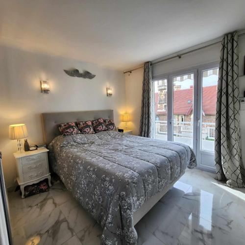 une chambre avec un lit et une grande fenêtre dans l'établissement Victoria - Dr Picaud - 3 Pieces avec climatisation - 5 min des Plages, à Cannes