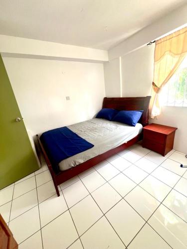 a bedroom with a bed with blue sheets and a window at Castle comfort ground floor apartment in Wallhouse