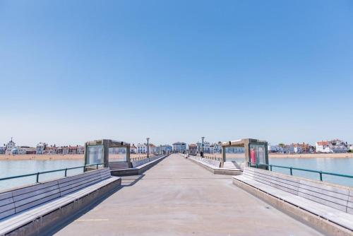 a pier with benches next to the water at Warwick Villa in Walmer